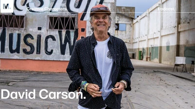 Graphic designer and design director David Carson standing in front of a wall that says Music